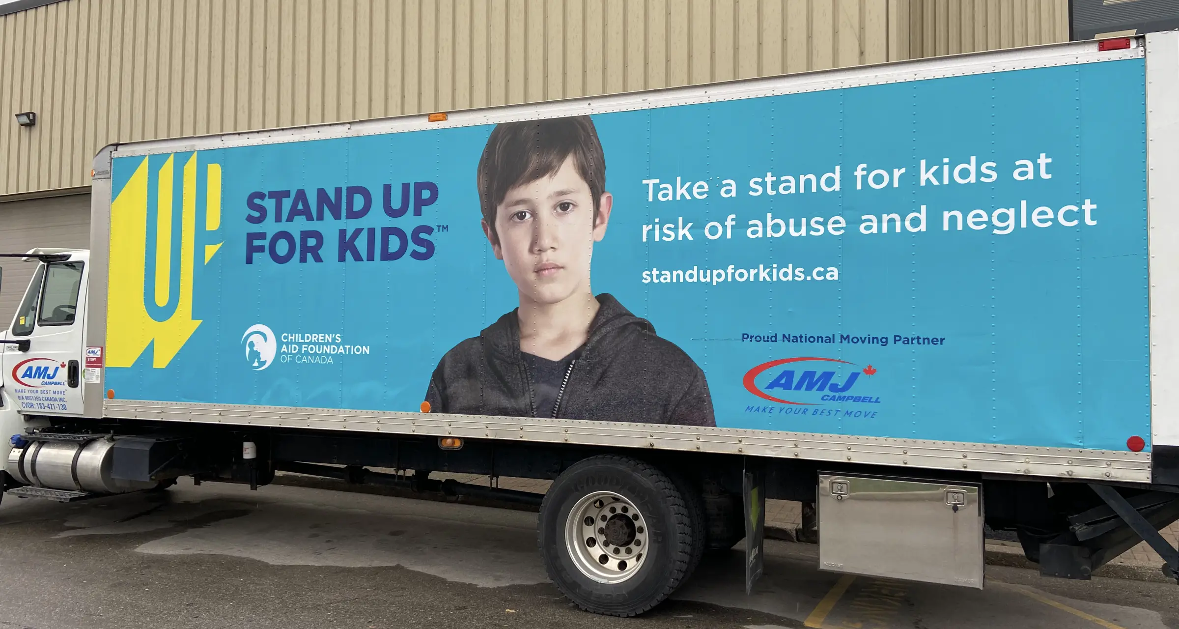 Stand Up for Kids advertisement on the side of a transport truck featuring a child in the centre