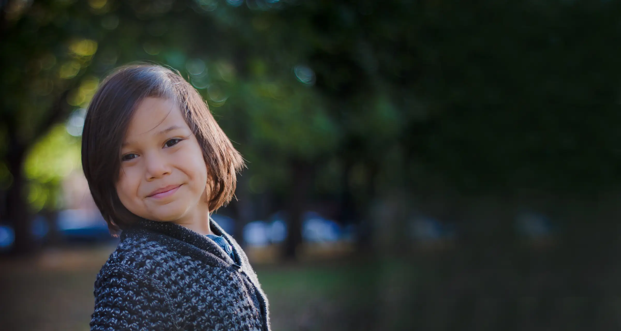 Child wearing sweater smiling at camera