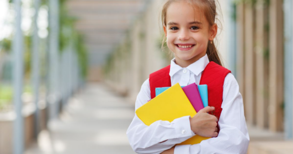 Young girl holding school books 
