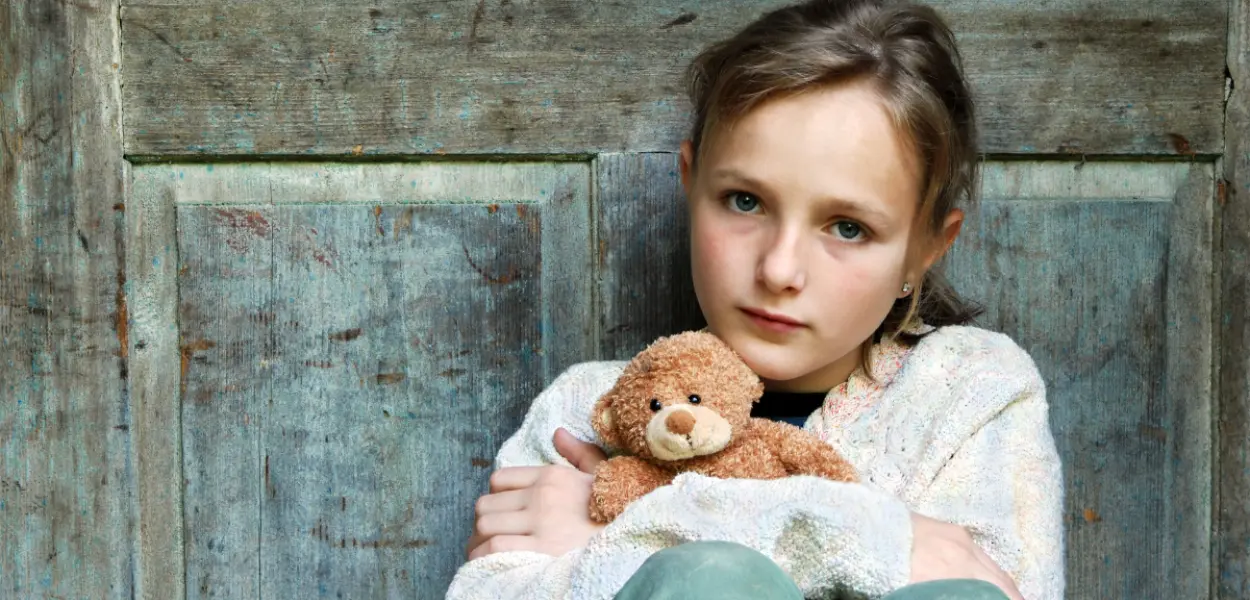 A young girl holding a teddy bear